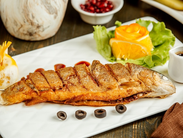 Free photo close up of fried whole fish served with sauce