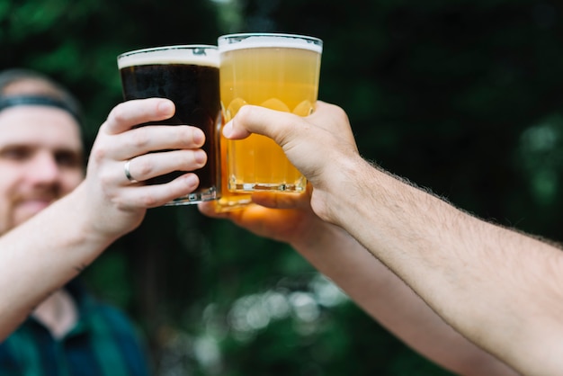 Close-up of a friend's hand cheering glass of alcoholic drinks