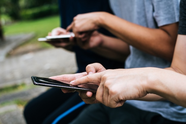 Close up of friends hands play with smartphone together.