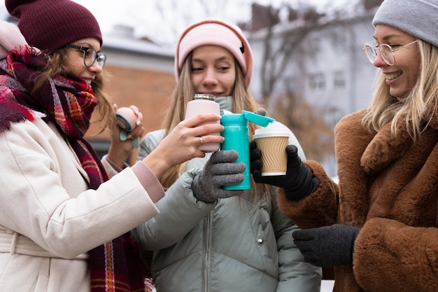 Free Photo close-up friends holding coffee cups