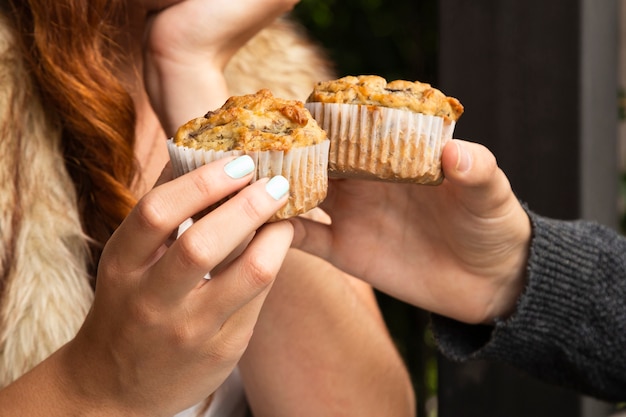 Close-up of friends holding cupcakes