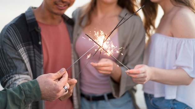 Free photo close-up friends holding fireworks