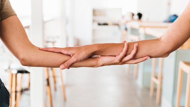 Free photo close-up friends holding hands