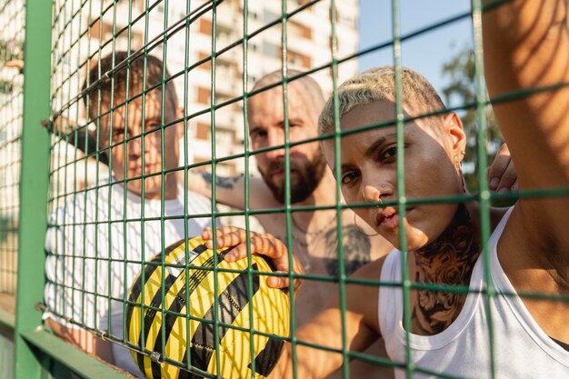 Close up friends posing behind fence