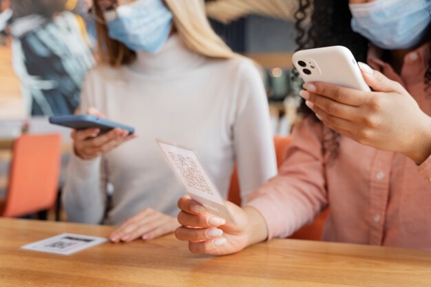 Close up friends scanning qr menu at restaurant