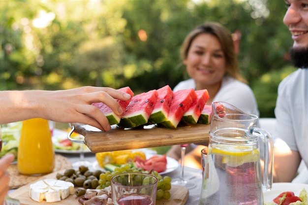 Close up friends at table with watermelon