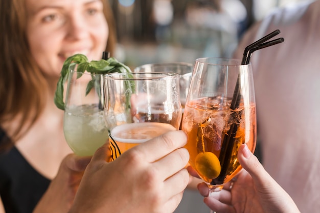 Close-up of friends toasting glasses of cocktail