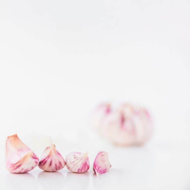 Free Photo close-up of garlic cloves on white backdrop