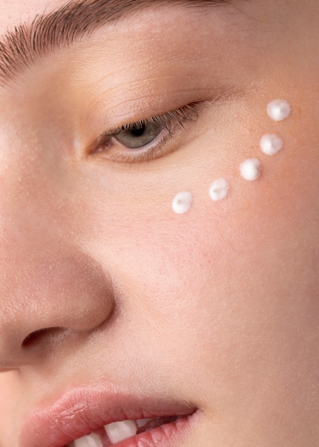 Close up girl applying eye cream