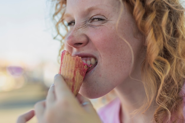 Free photo close-up girl biting ice cream cone