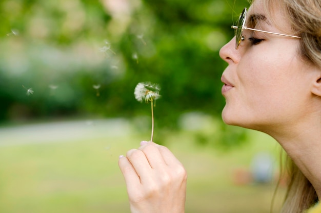 Free Photo close-up girl blowing dandelion