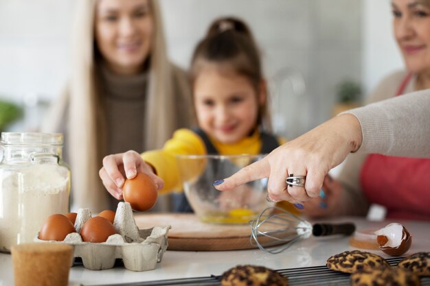 Close up on girl cooking with her mother and grandmother