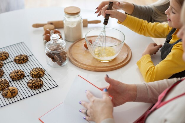 Close up on girl cooking with her mother and grandmother