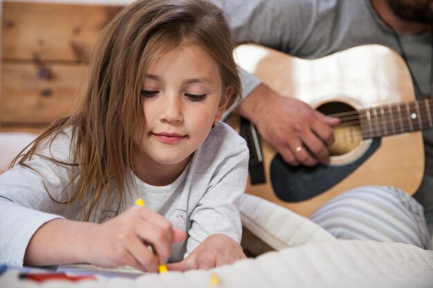 Close-up of girl drawing with her father background