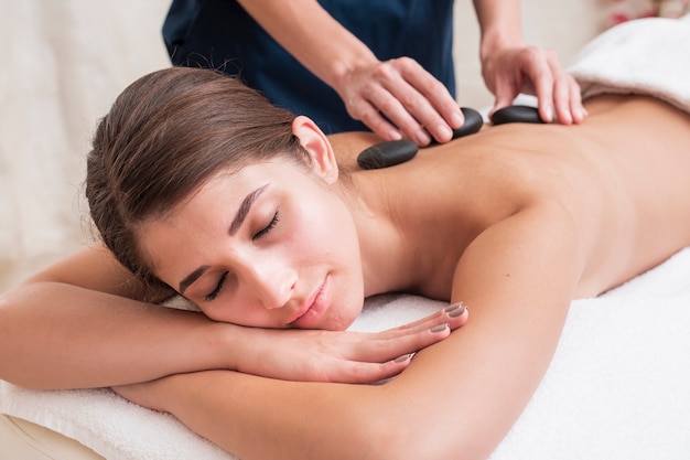 Free photo close-up girl getting stone spa treatment