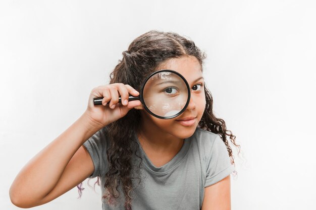 Close-up of a girl looking through magnifying glass