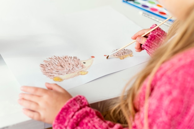 Free photo close-up girl painting indoors  with brush