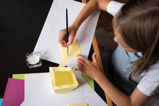 Close up girl painting paper