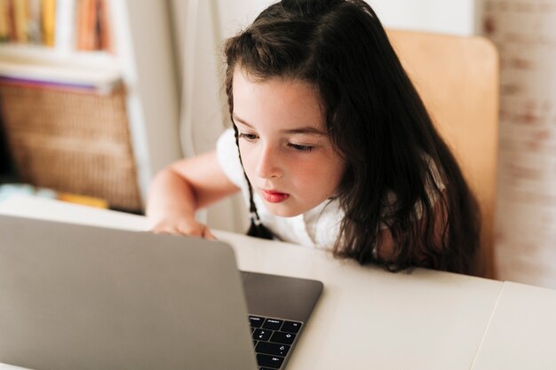 Close-up girl paying attention to her laptop