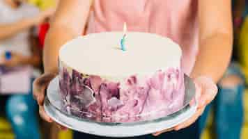 Free photo close-up of a girl's hand holding birthday cake