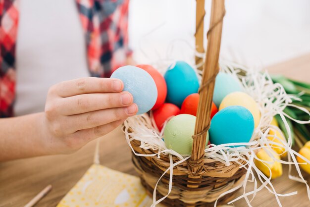 Close-up of a girl's hand holding blue easter egg