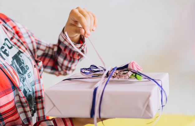 Close-up of a girl's hand unwrapping birthday gift