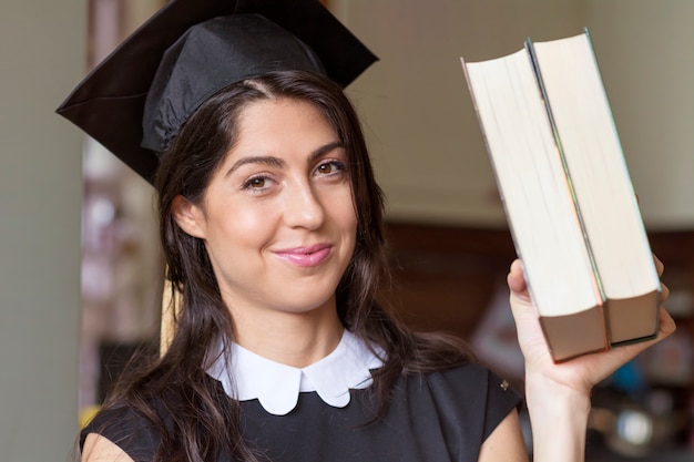 Close-up of girl showing two books