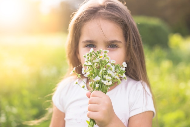 Free photo close-up of a girl smelling white flowers