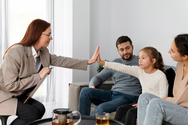 Close up girl and therapist high five