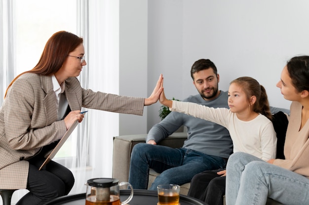 Close up girl and therapist high five