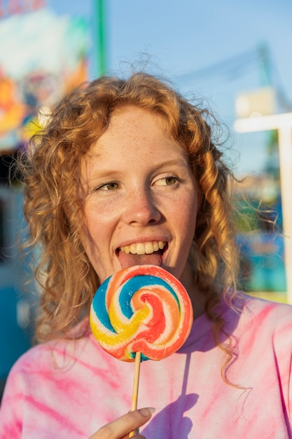 Free photo close-up girl with lollipop looking at away