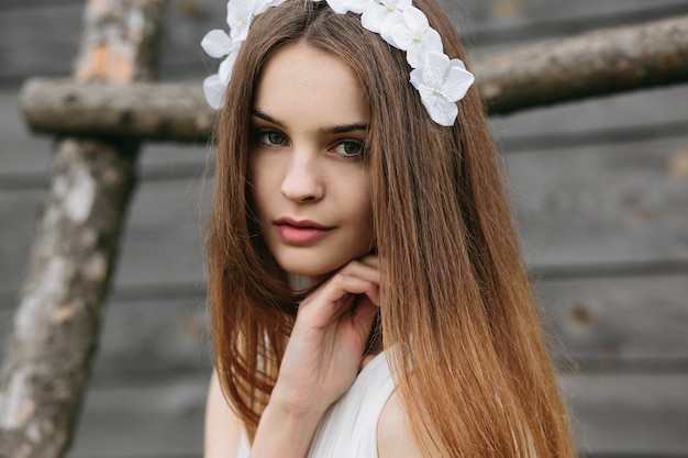 Close-up of girl with wreath touching her cheek