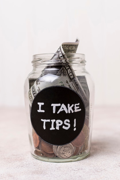 Close-up glass with money as tips