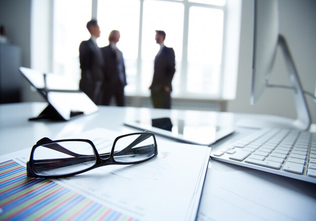 Close-up of glasses with businesspeople background