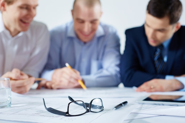 Free Photo close-up of glasses with co-workers blurred background