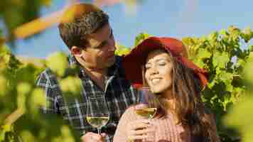 Free photo close up of gorgeous couple embracing each other while holding glasses of wine in hands.