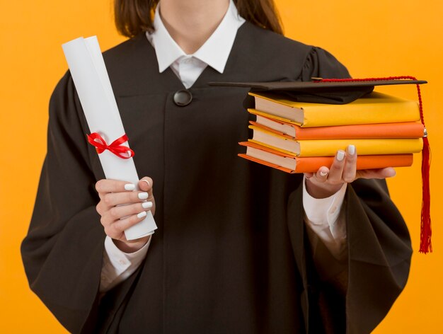 Close up graduate student holding books