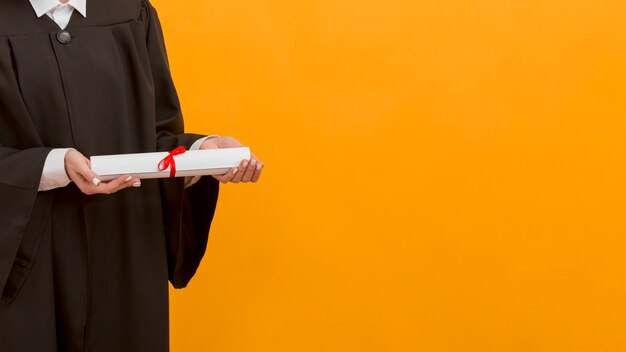 Close up graduate student holding diploma