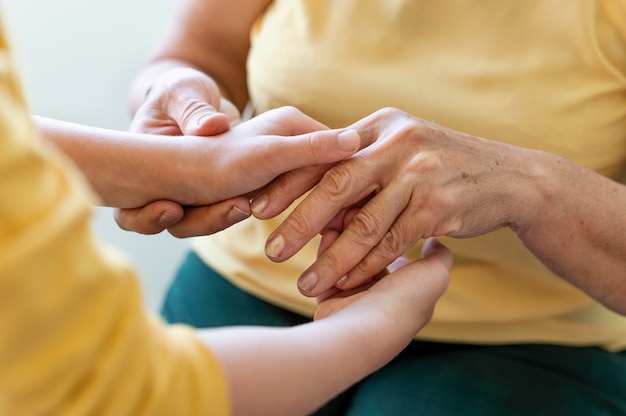 Free photo close up grandmother holding kid hands