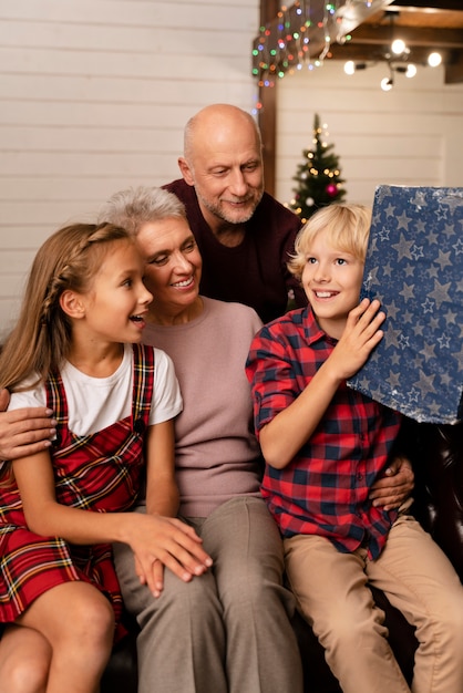 Close up on grandparents and kids opening gifts