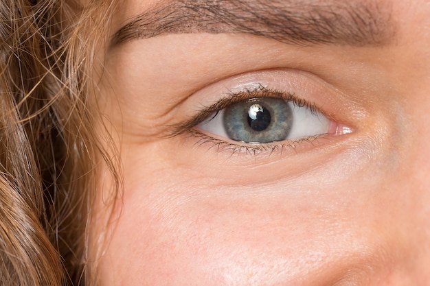 close up gray eye on face of young beautiful caucasian girl