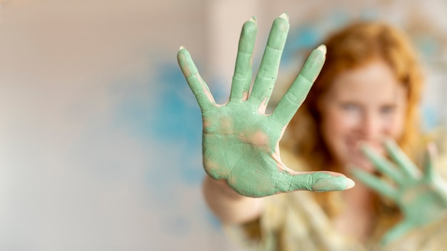 Free Photo close-up green paint on woman's palms