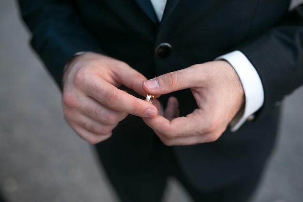 Free Photo close-up of groom holding a wedding ring