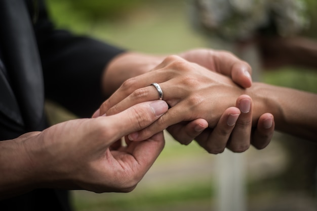 Free photo close up of groom wears the ring bride in wedding day. love, happy marry concept.