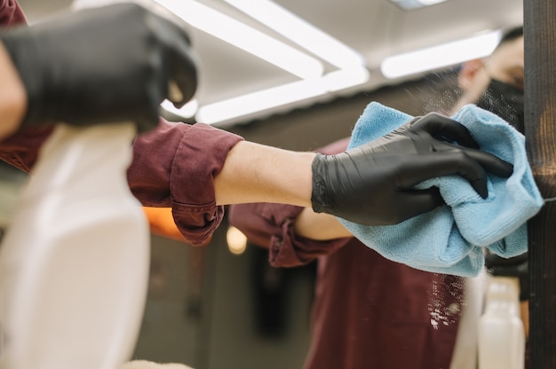 Close-up of hairstylist cleaning the mirror