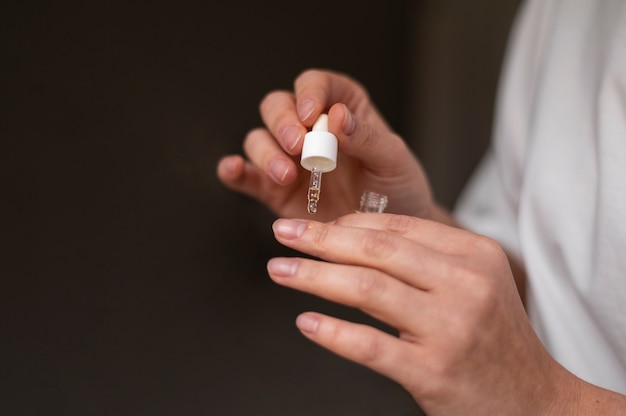 Free photo close up hand applying nail treatment