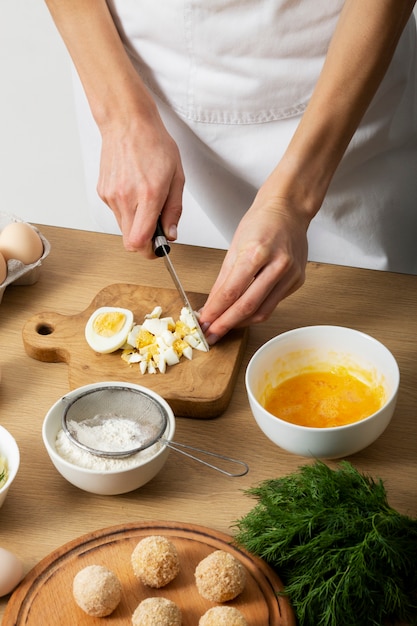 Close up hand cutting eggs