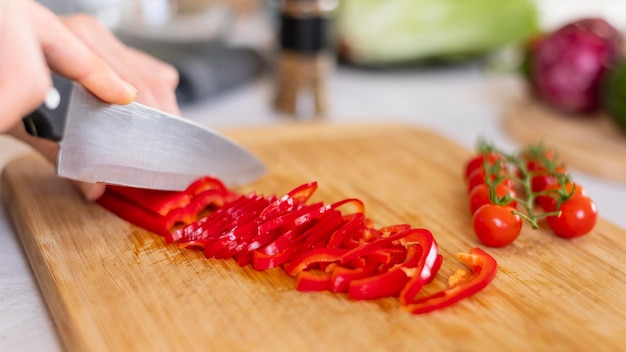 Close up hand cutting pepper  with knife