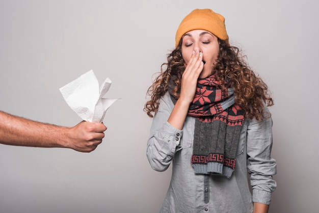 Free photo close-up of hand giving tissue paper to sick woman suffering from cold and flu