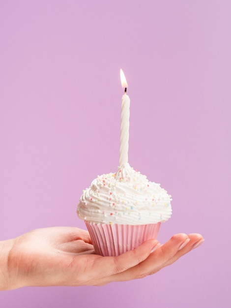 Close-up hand holding birthday muffin